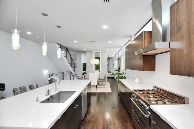 kitchen featuring range hood, a spacious island, dark wood-style flooring, a sink, and stainless steel appliances