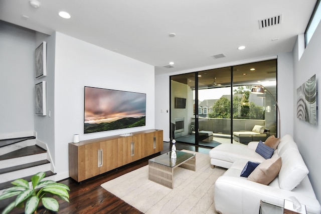 living room featuring a wall of windows, recessed lighting, visible vents, and dark wood-style flooring