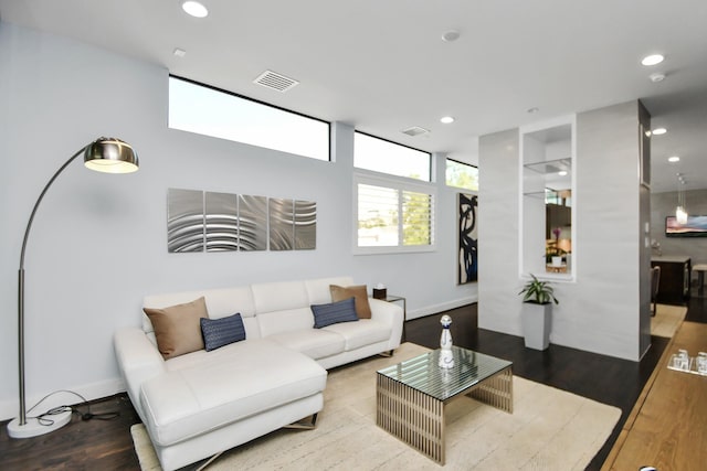 living area featuring visible vents, recessed lighting, baseboards, and wood finished floors