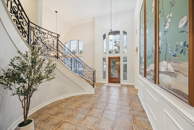 entrance foyer featuring baseboards, stairs, and a towering ceiling