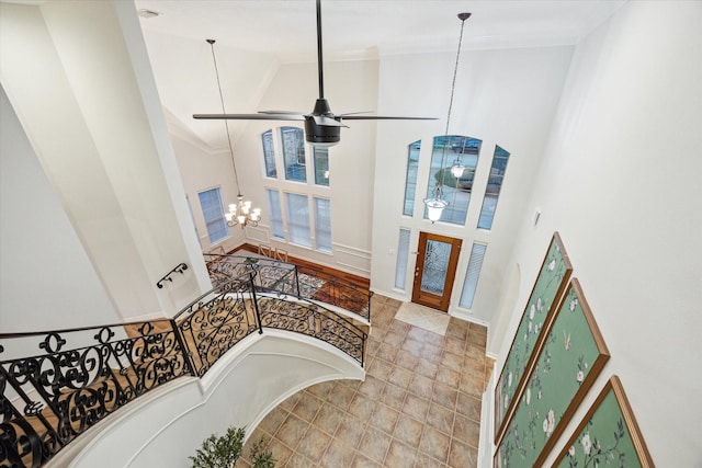 entryway featuring a chandelier, high vaulted ceiling, and baseboards