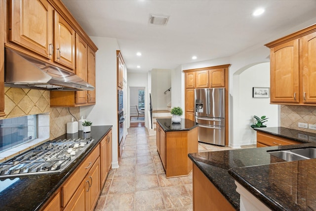 kitchen featuring under cabinet range hood, visible vents, dark stone countertops, and appliances with stainless steel finishes