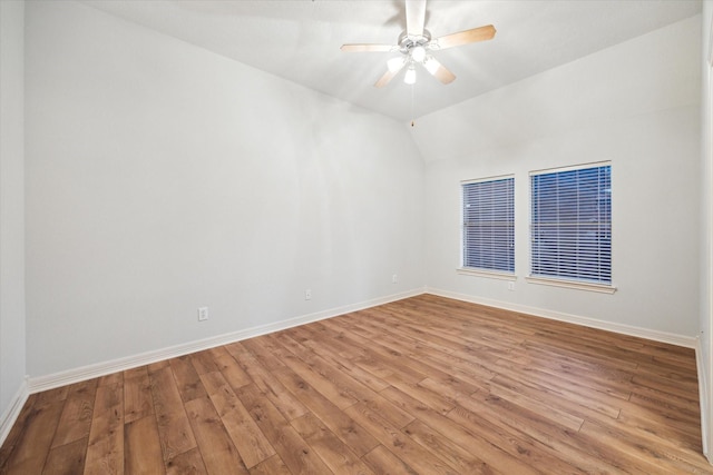 spare room with hardwood / wood-style floors, baseboards, lofted ceiling, and ceiling fan