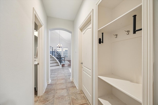 mudroom with arched walkways and a chandelier