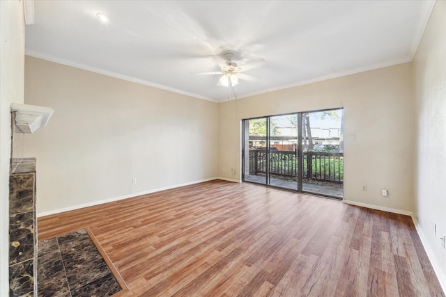 interior space featuring ornamental molding, light wood-style flooring, baseboards, and a ceiling fan