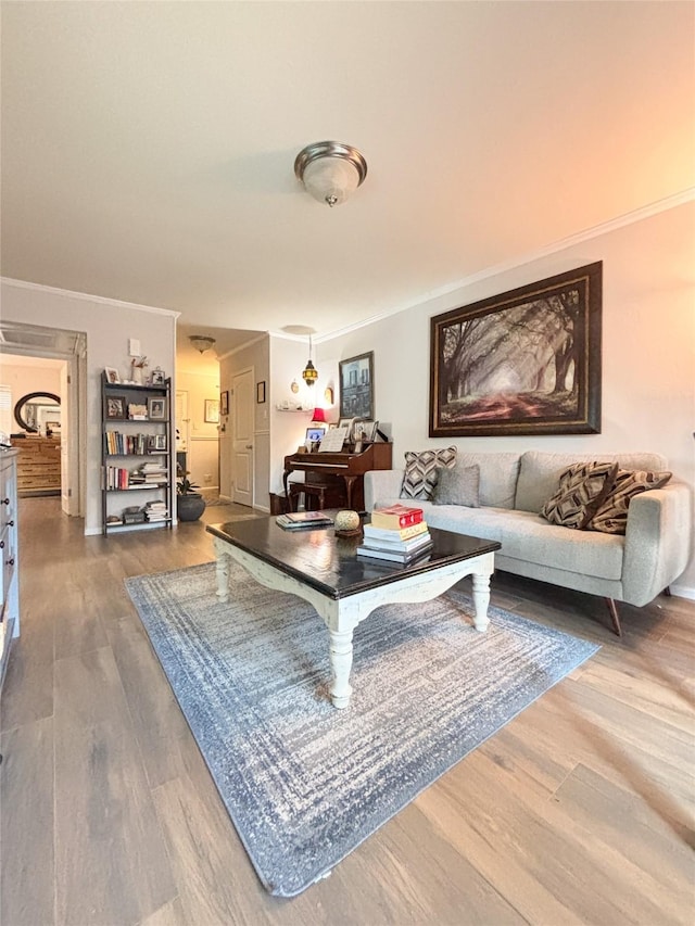 living area featuring ornamental molding and wood finished floors