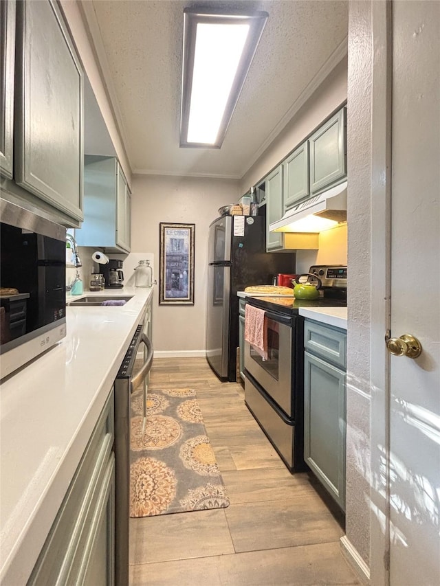 kitchen featuring under cabinet range hood, appliances with stainless steel finishes, light countertops, and light wood-style floors