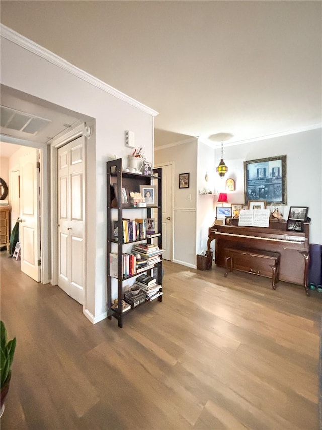 interior space featuring baseboards, wood finished floors, and crown molding