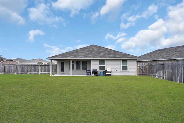 rear view of house with a patio area, a lawn, and a fenced backyard