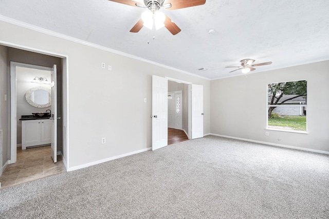 unfurnished bedroom featuring carpet floors, ornamental molding, a textured ceiling, and baseboards