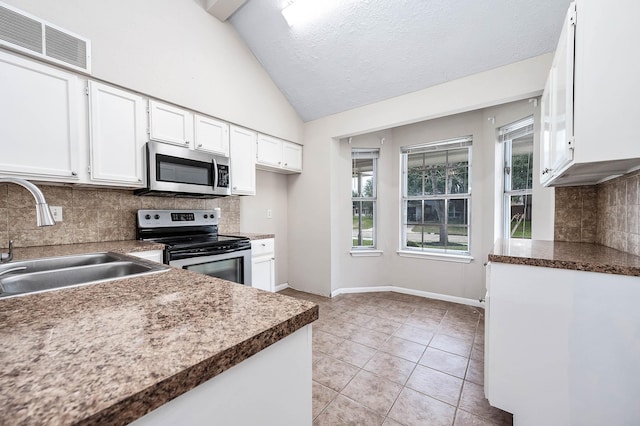 kitchen featuring light tile patterned flooring, stainless steel appliances, a sink, visible vents, and white cabinets