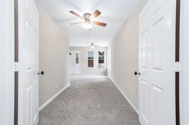 hall featuring carpet and baseboards