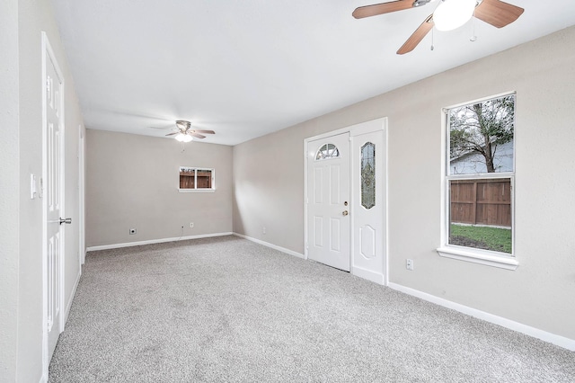 entryway with carpet floors, baseboards, and a ceiling fan