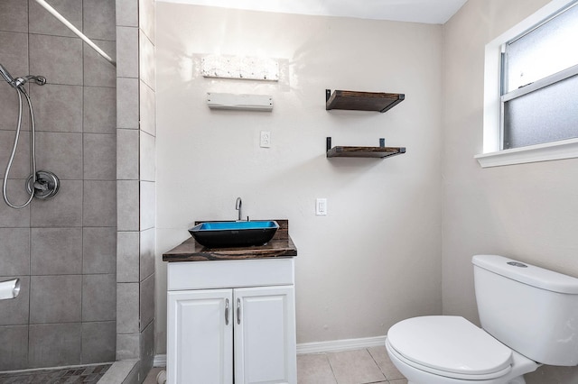 full bath with baseboards, toilet, tile patterned floors, a tile shower, and vanity