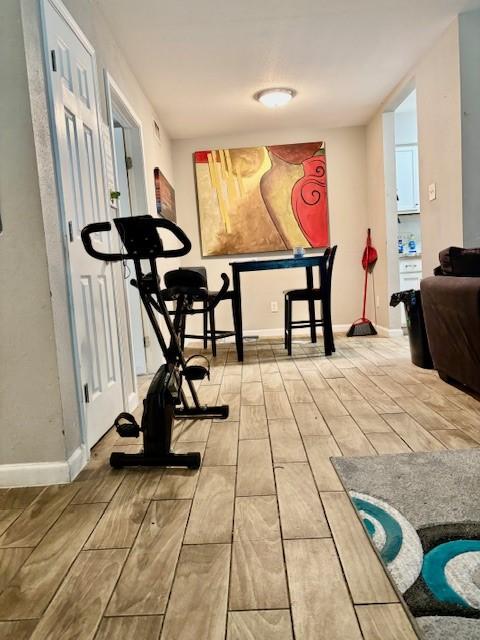 workout room featuring wood tiled floor and baseboards