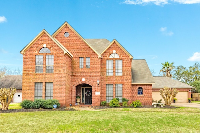 view of front of property with brick siding, a shingled roof, a front yard, a garage, and driveway