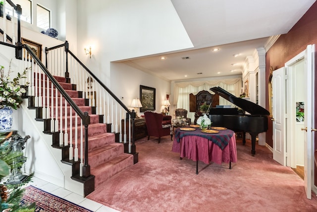 interior space featuring crown molding, recessed lighting, visible vents, a towering ceiling, and stairs