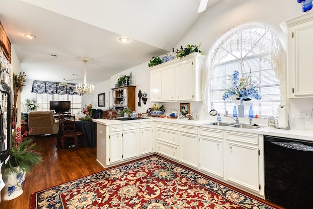 kitchen with light countertops, a sink, a chandelier, dishwasher, and a peninsula