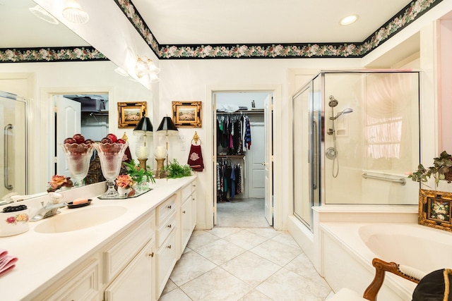 bathroom featuring a spacious closet, a stall shower, and vanity