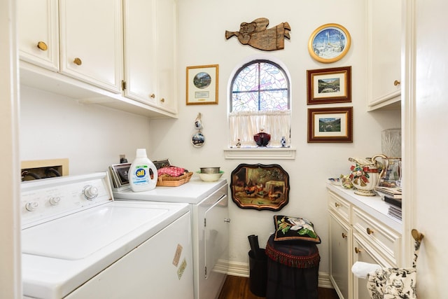 laundry room with dark wood finished floors, washing machine and clothes dryer, cabinet space, and baseboards