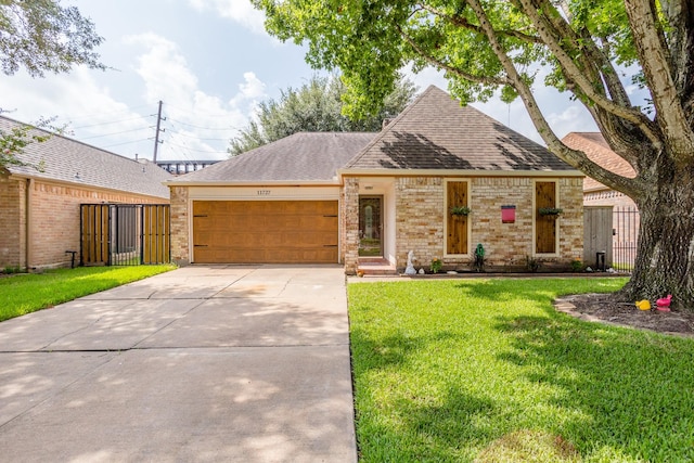 view of front of house with a front yard, a gate, fence, a garage, and driveway