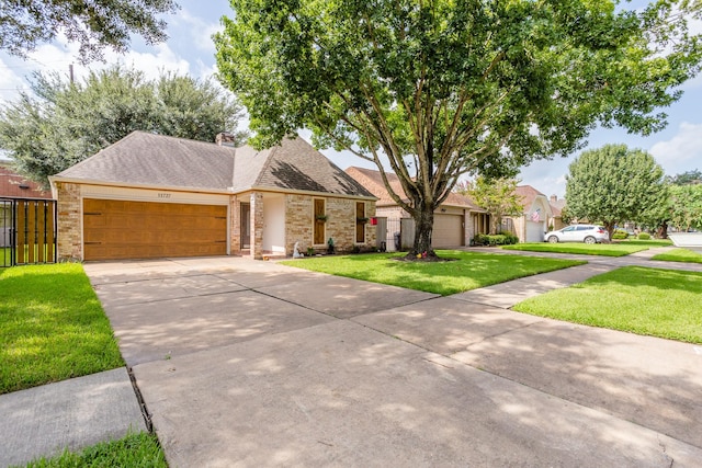 view of front of house featuring driveway, a chimney, an attached garage, a front yard, and brick siding