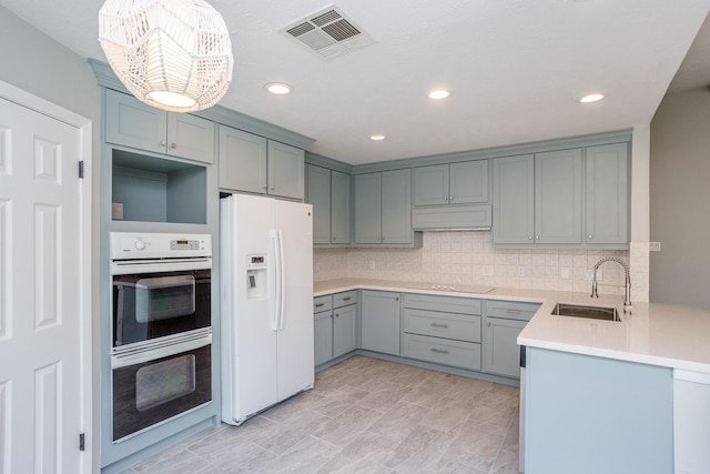 kitchen featuring white appliances, a sink, visible vents, and gray cabinetry