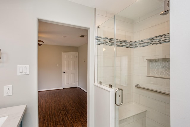 full bathroom with wood finished floors, vanity, baseboards, visible vents, and a shower stall