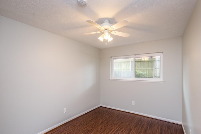 spare room featuring a textured ceiling, wood finished floors, a ceiling fan, and baseboards