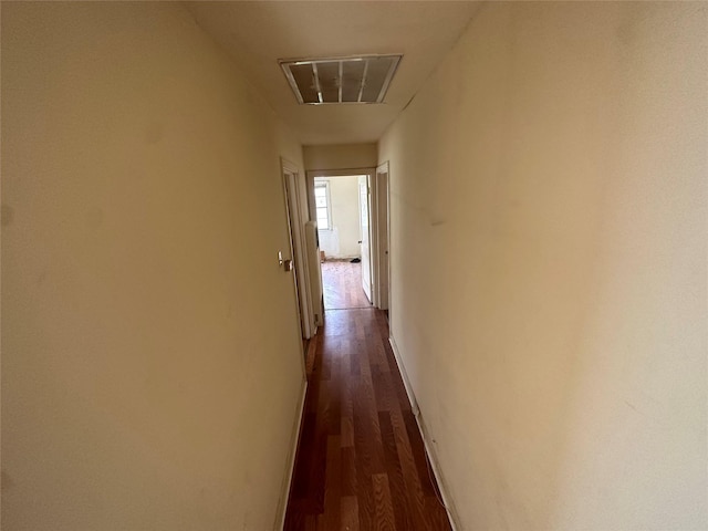 corridor featuring baseboards and dark wood finished floors