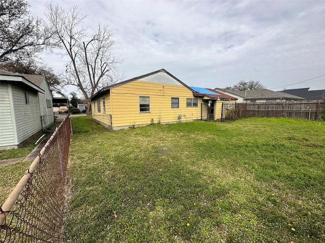 rear view of property featuring a fenced backyard and a yard