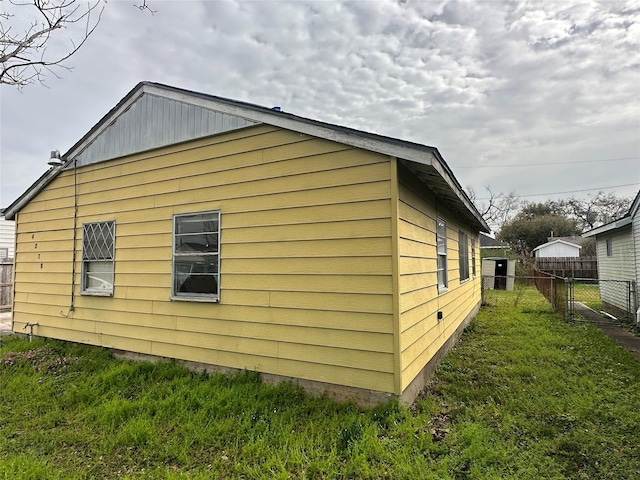 view of side of home featuring a yard and fence