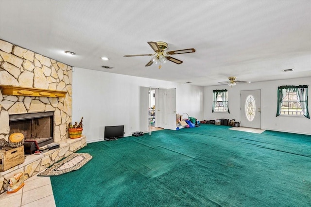 unfurnished living room featuring a healthy amount of sunlight, a fireplace, visible vents, and tile patterned floors