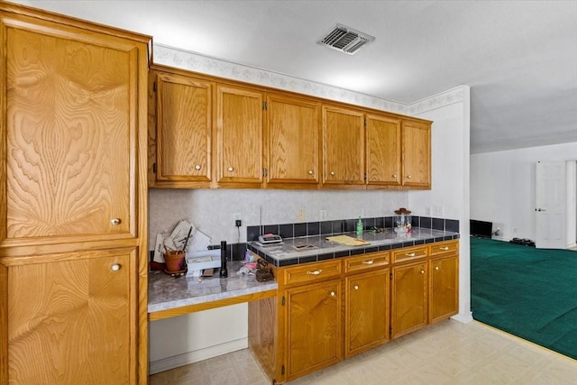 kitchen featuring light floors, visible vents, and brown cabinets