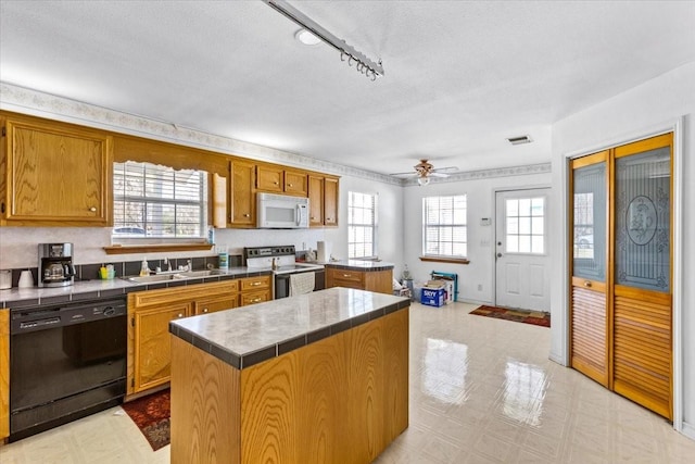 kitchen featuring white microwave, visible vents, electric range oven, light floors, and dishwasher