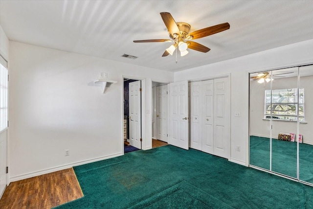 unfurnished bedroom with ceiling fan, two closets, visible vents, and baseboards