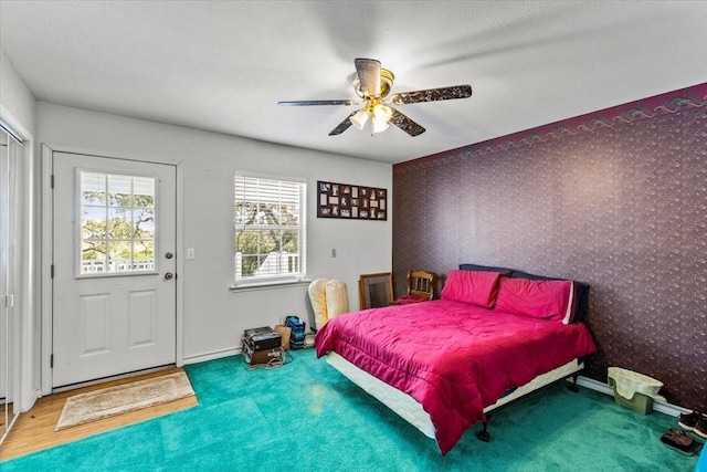 bedroom with ceiling fan, baseboards, and wallpapered walls