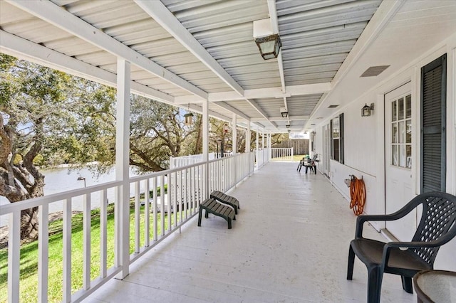 view of patio / terrace featuring a porch and a water view