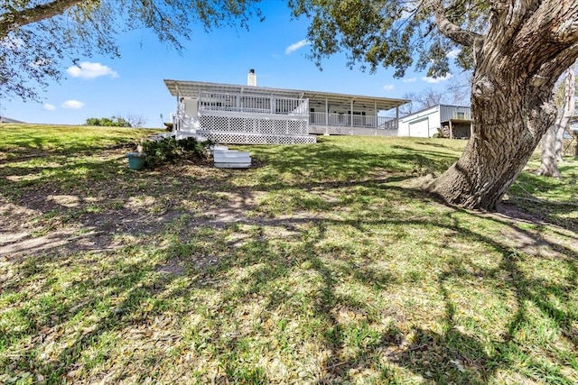 back of property with a chimney and a lawn