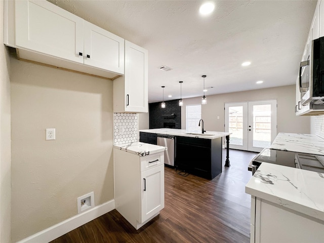 kitchen with tasteful backsplash, appliances with stainless steel finishes, dark wood-style flooring, and french doors