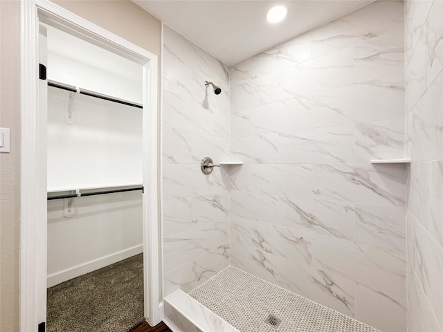 full bath with a stall shower, a spacious closet, baseboards, and recessed lighting