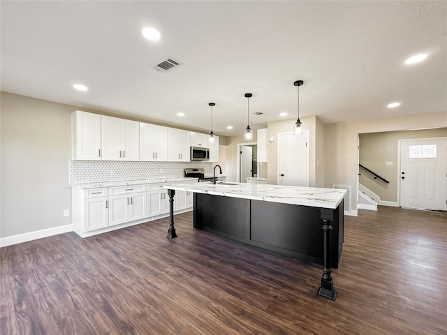 kitchen with dark wood-style floors, white cabinetry, visible vents, and stainless steel appliances