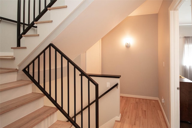 staircase with wood finished floors and baseboards