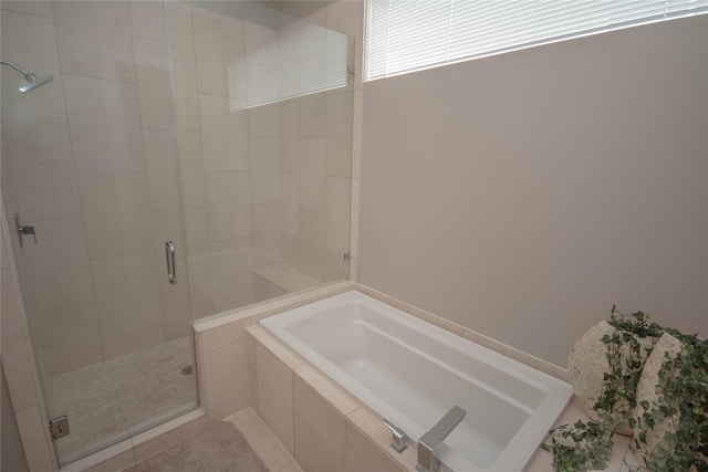 bathroom featuring a bath and a shower stall