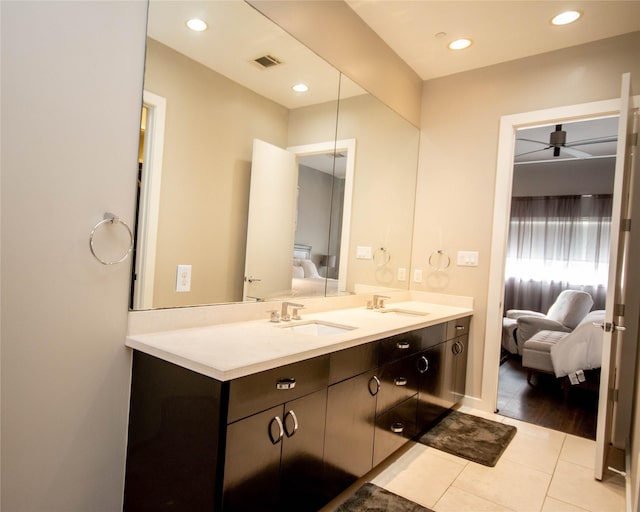 bathroom with ensuite bath, double vanity, visible vents, and a sink