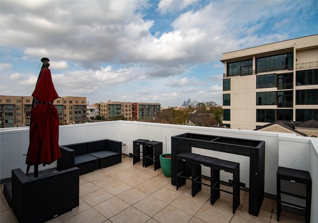 view of patio / terrace with a city view, outdoor lounge area, and a balcony