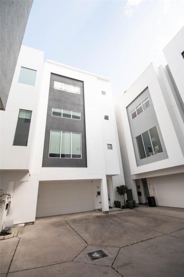 view of front of house featuring a garage, driveway, and stucco siding