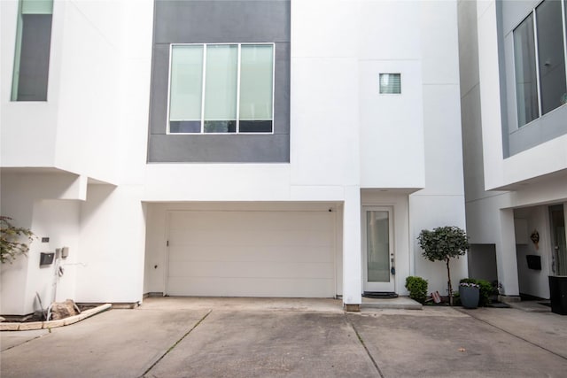 view of front facade featuring a garage, driveway, and stucco siding