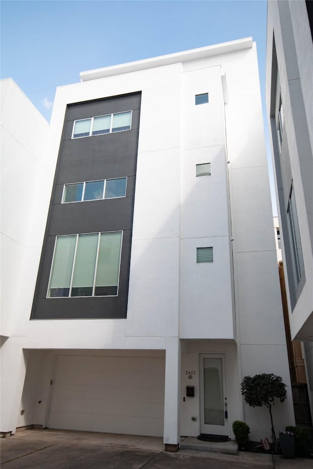 view of building exterior with concrete driveway and an attached garage