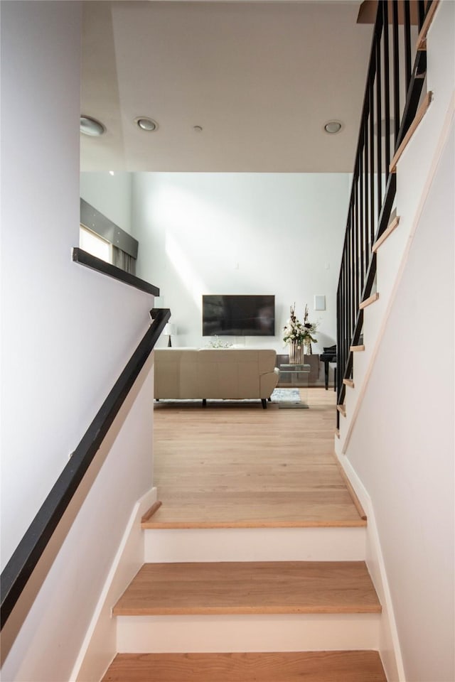 stairway with wood finished floors and baseboards